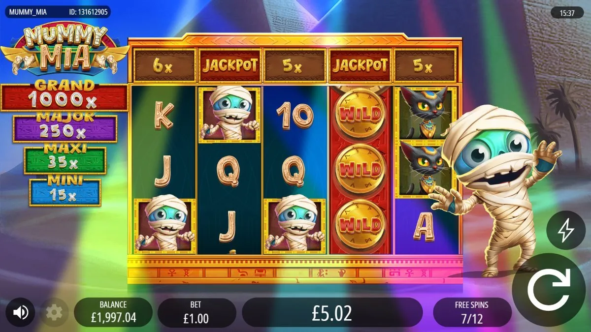 Free spins 7/12 on a rainbow-spotlight backdrop, the per-reel bar reading 6× / JACKPOT / 5× / JACKPOT / 5× and reel four full of WILD coins — win at £5.02 and climbing.